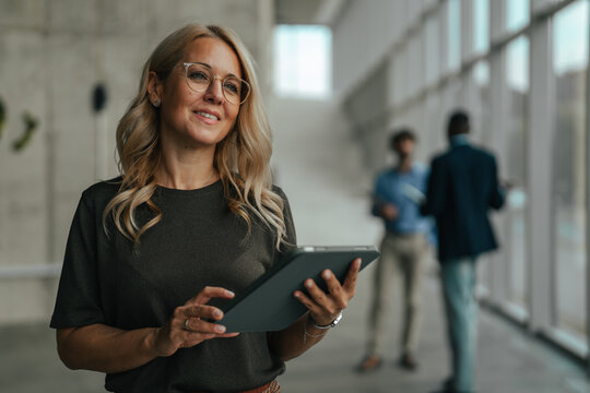 Confident business woman holding digital tablet in office