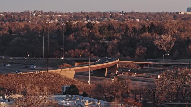 Highway exchange with car traffic moving on overpasses during a warm sunset 4K video