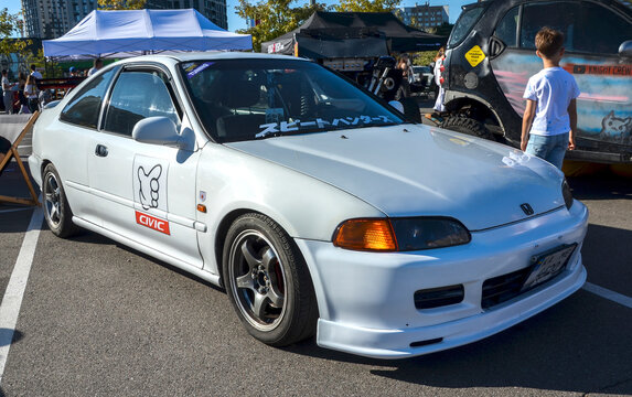 Classic white 5th generation Honda Civic Coupe features custom aftermarket wheels, amber corner lights, and JDM styling, highlighting 90s Japanese tuning culture