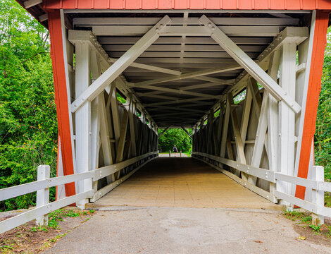 Female Hiker Crossing The Everett Covered Bridge Over Furnace Run Creek, Cuyahoga Valley National Park, Ohio, USA