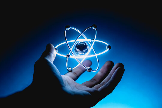 Hand Holding Glowing Atomic Model Representation