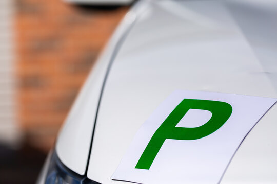 Magnetic green p plate for provisional license holder driver on car parked on driveway