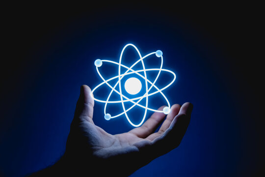 Open Palm Holding Glowing Atomic Particle Symbol
