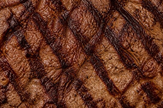 Grilled beef steak with char marks closeup texture
