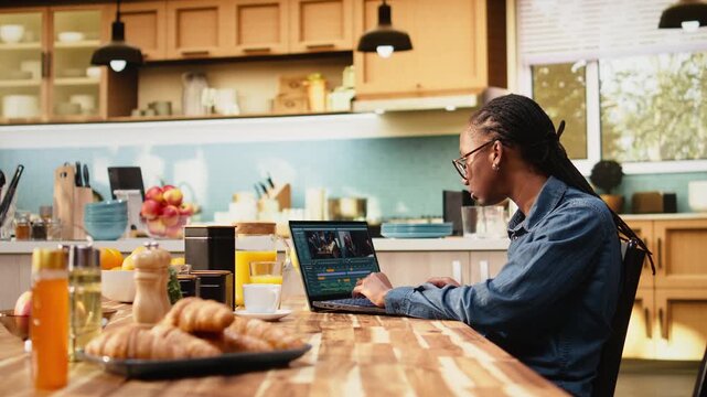 Content creator edits video montage on laptop with color grading, videography and post production techniques, using color correction and VFX tools in a creative process while working indoors.
