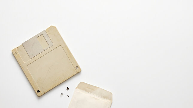 Top view of an obsolete vintage floppy disk on a blank white background with copy space.