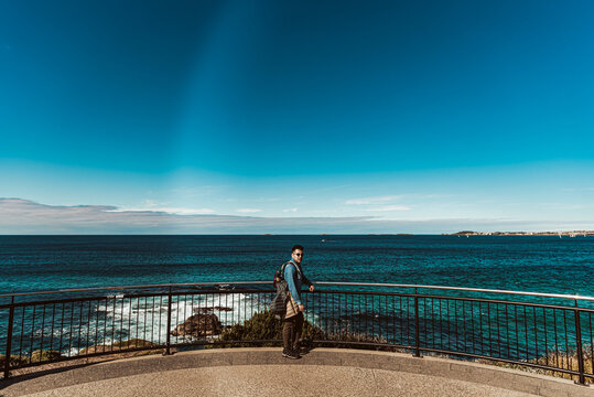 person on a viewing platform overlooking the ocean