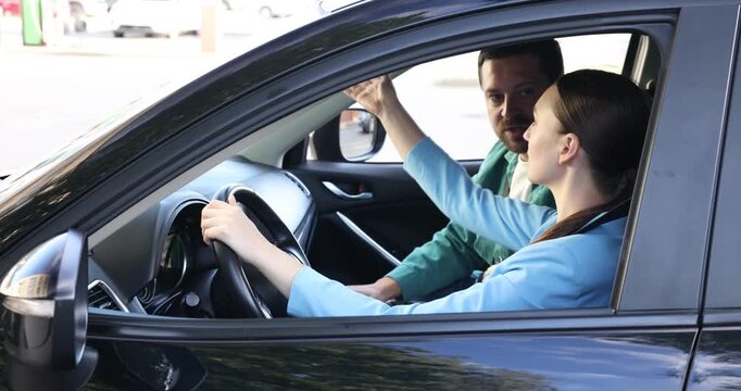 Driving school. Instructor teaching student how to adjust mirrors in car