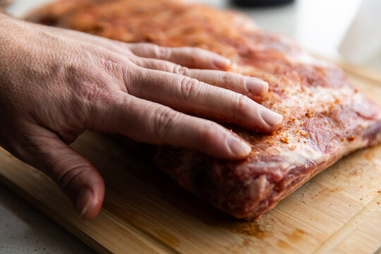 rubbing a spice mix onto a rack of ribs