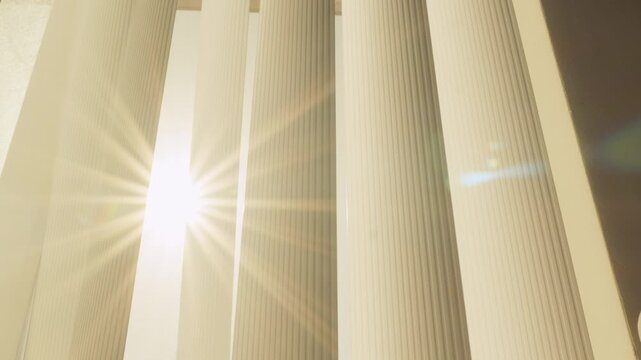 Bright Morning Sun Flare Bursting Through Vertical Window Blinds