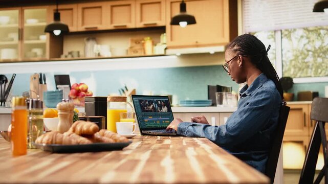 Woman content creator edits clips for video production at home, using VFX tools and assets for cinematic montage as a productive digital nomad.