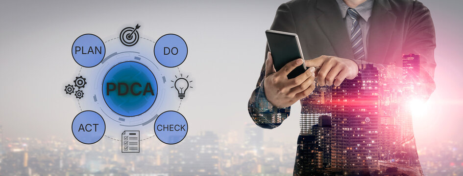 Business Professional Engaged in Strategic Planning Techniques with PDCA Cycle Against Cityscape Background for Continuous Improvement Process. Bitwise.