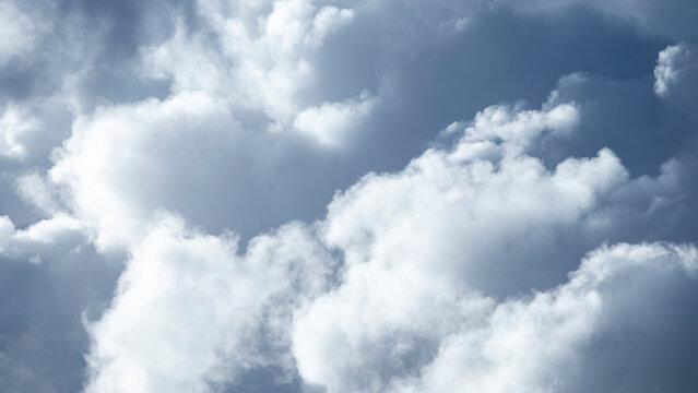 Dramatic storm clouds gathering in the bright blue sky.A stunning, high-contrast photograph capturing heavy storm clouds building up against a vibrant blue sky.