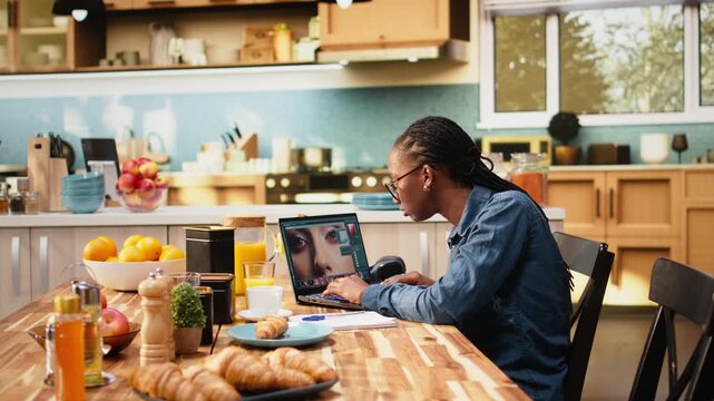 Photo editor retouches images on laptop and selects photos in software during remote work and Gen Z lifestyle, using color correction and visual effects to enhance photography for media content.