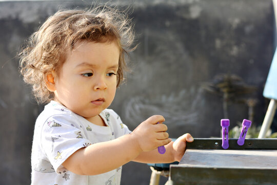 Toddler playing with clothespins.