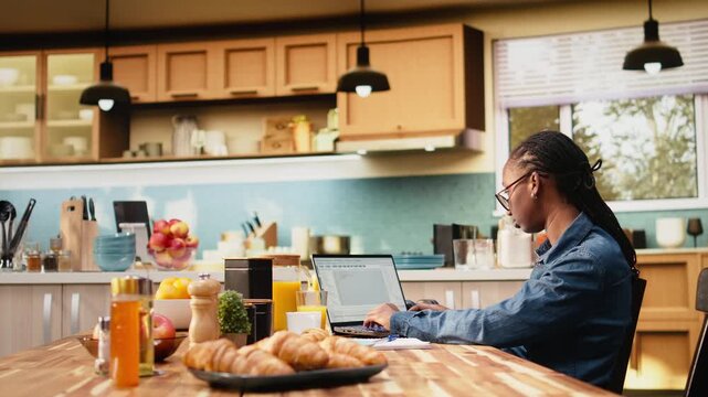 Black woman programmer develops web code and software systems on laptop, coding and debugging UX processes with global network connectivity while working remotely in a high-tech software role.