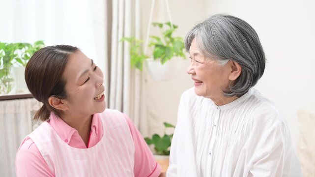 訪問介護で高齢者と会話するホームヘルパー、在宅介護、見守り、コミュニケーション、笑顔で寄り添う見つめ合う女性介護職の動画