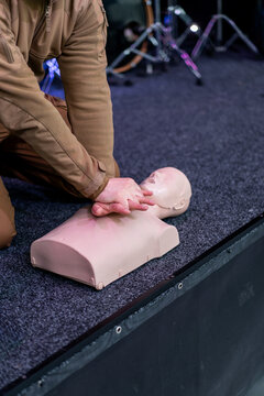 People practicing cardiopulmonary resuscitation CPR and basic life support techniques on a medical training manikin during a first aid course. Emergency response education and lifesaving skills.