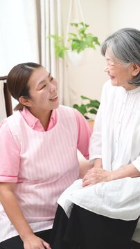 訪問介護で高齢者と会話するホームヘルパー、在宅介護、見守り、コミュニケーション、笑顔で寄り添う見つめ合う女性介護職の縦動画