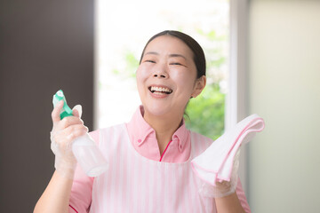 家事代行で掃除をする女性スタッフ、訪問介護、ホームヘルパー、手袋をして清掃や掃除をするイメージカメラ目線で大笑い © kapinon