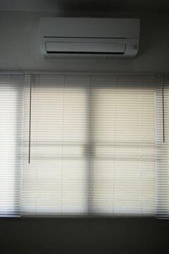 Interior of a modern room with horizontal window blinds, natural daylight.