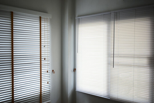 Interior of a modern room with horizontal window blinds, natural daylight.