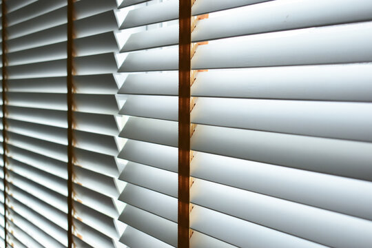Interior of a modern room with horizontal window blinds, natural daylight.