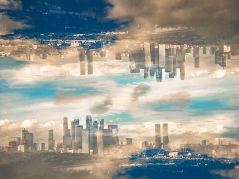 Surreal conceptual image of upside down mirrored modern city skyline in the clouds, parallel universe and alternate reality concept
