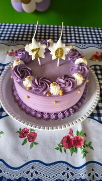 Purple 70th Birthday Cake with Star Candles and Gold Sprinkles