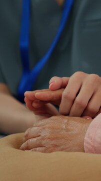 Senior wellness care support hand touch comfort compassion gentle aid close up caregiver giving gentle abdominal touch in medical setting calm patient support
