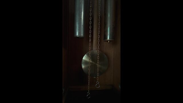Close up vintage grandfather clock pendulum swinging back and forth, time passing and hypnosis concept