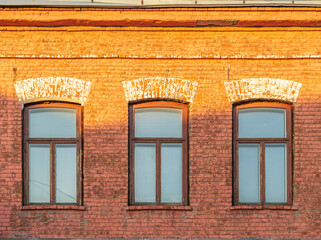 Three windows of the old mansion 19 century with brown bricks wall © Dmitrii Potashkin