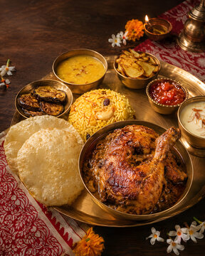 Festive Indian Thali with Roast Chicken, Biryani and Puri on Brass Platter