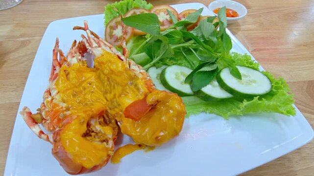 Delicious freshly cooked lobster with a vegetable salad on a plate at a restaurant.	
