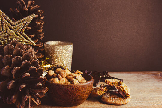 Festive Christmas table offering traditional sweets, nuts, chocolate, and dried figs, creating a cozy and inviting atmosphere for holiday celebrations and evening gatherings