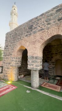 Historic stone arches and colorful prayer mats at the sacred Al Fath Mosque in Medina.