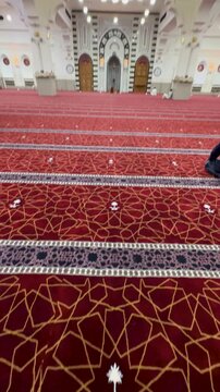 Sacred Al Fath Mosque in Medina with red carpet, open roof terrace, and historic front.