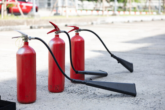 Red fire extinguishers lined up on outdoor concrete