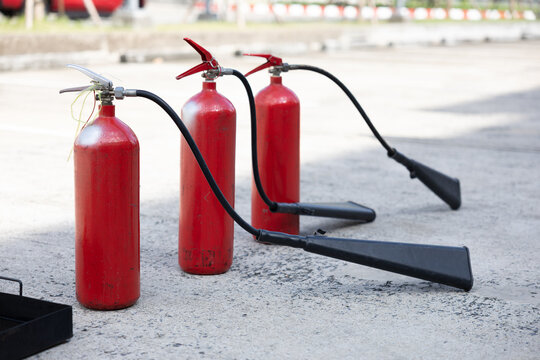 Three red fire extinguishers with black discharge horns
