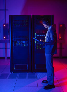 Data Center Technician with Tablet in Server Room