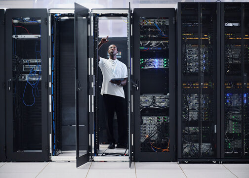 African American IT professional monitoring servers in a modern data center