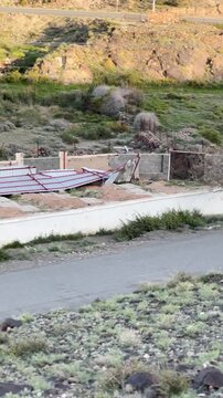 Panning shot of a rural mountain landscape featuring a road, passing car, and camel.