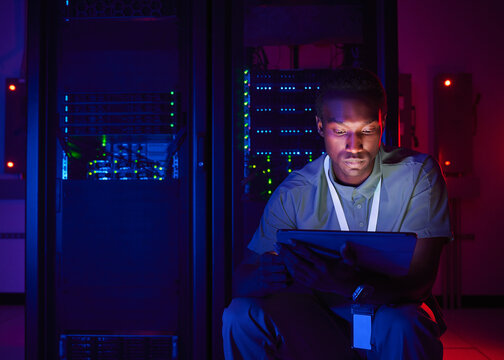 IT Technician Monitoring Servers with Tablet in Data Center