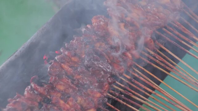 Chicken Satay Skewers Grilling on Charcoal Grill with Smoke