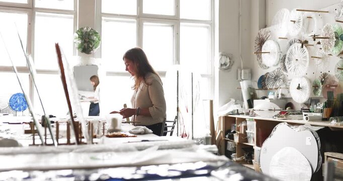 Skilled woman crafts professional designing decorative object from custom glass shaping new product idea on paper preparing artistic visualization by drawing model by hand in glasswork art studio