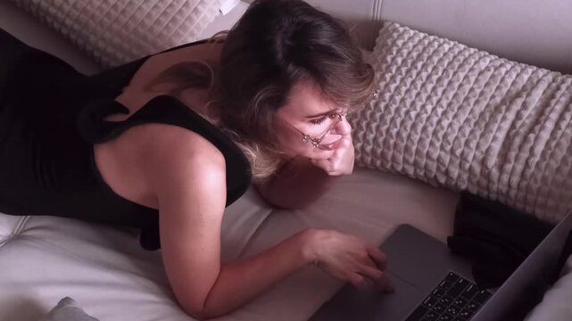 Digital routine. Freelance lifestyle. Skilled female entrepreneur relaxing on sofa at home using laptop for professional occupation.
