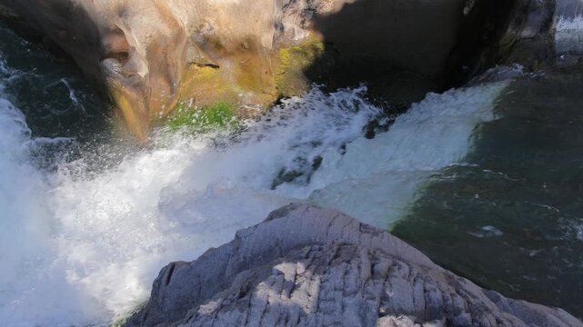 Rushing mountain stream water flowing over rocks with white foam