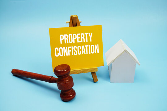 Property Confiscation text with judgment gavel and house model on blue background