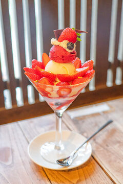 Elegant strawberry parfait with ice cream sorbet cream and fresh berries in a tall glass