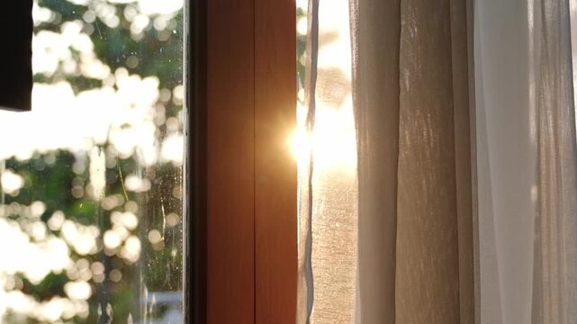 Slow motion of the curtains on the window There was morning light streaming through the bedroom window. Look out over the mountains and trees as the sun rises.	
